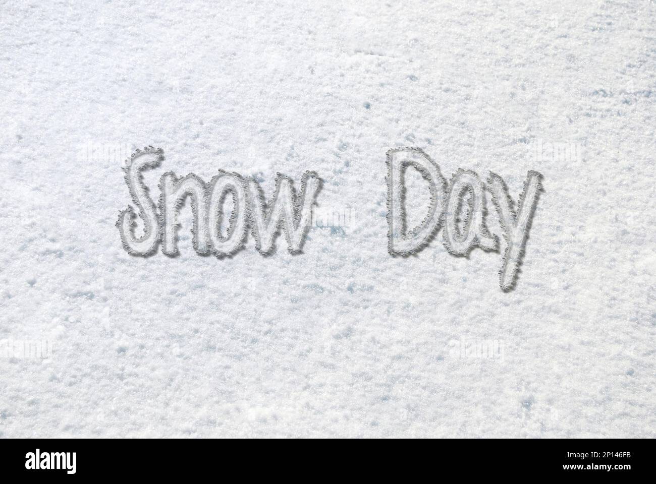 Texto del día de la nieve en la nieve blanca en el suelo Foto de stock