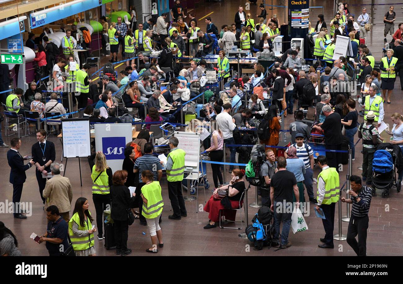 Passengers wait in line to be rebooked at the SAS ticket counter at
