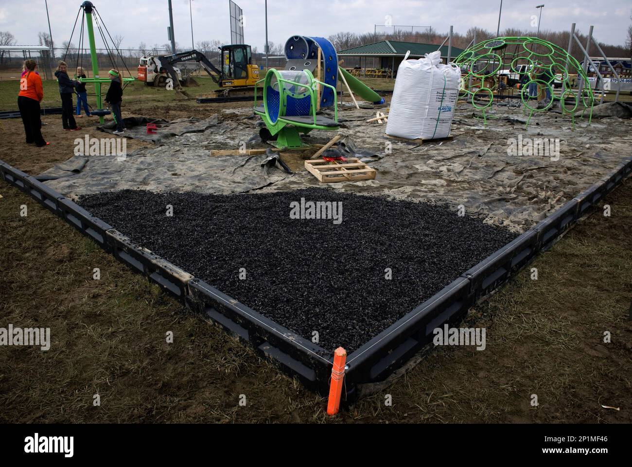 A section of black rubberized mulch is placed in a corner of the Play