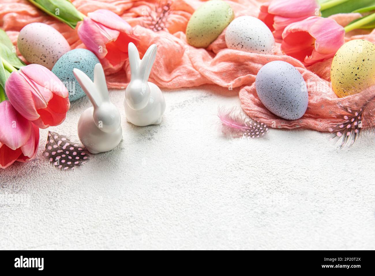 Un ramo de tulipanes, conejos de Pascua y huevos sobre fondo de hormigón. Decoración de Pascua y flores. Tarjeta de felicitación de Pascua. Foto de stock