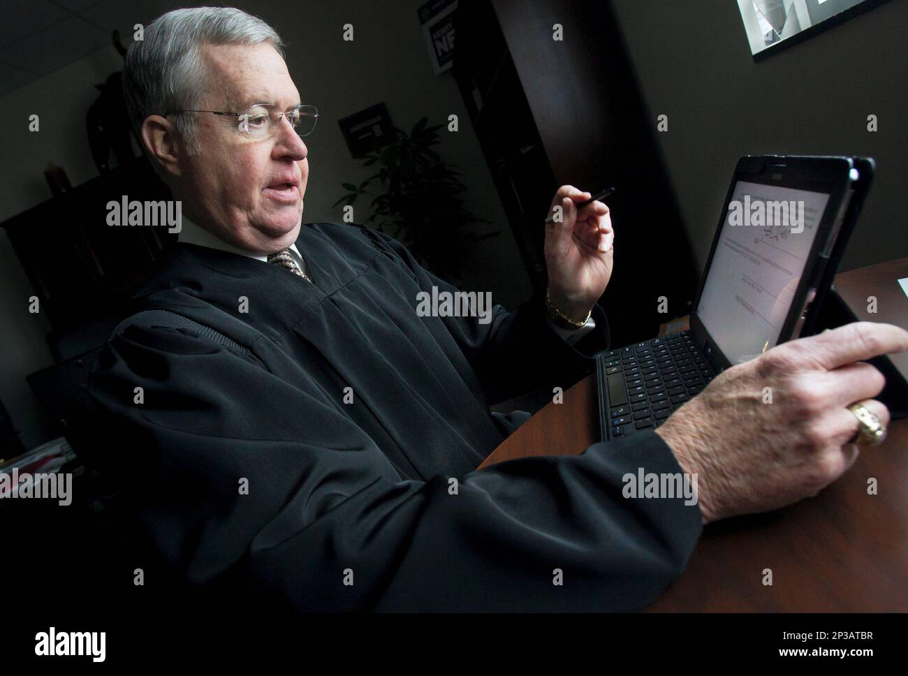 District Court Judge Kerry Neves demonstrates software technology that allows him to use his