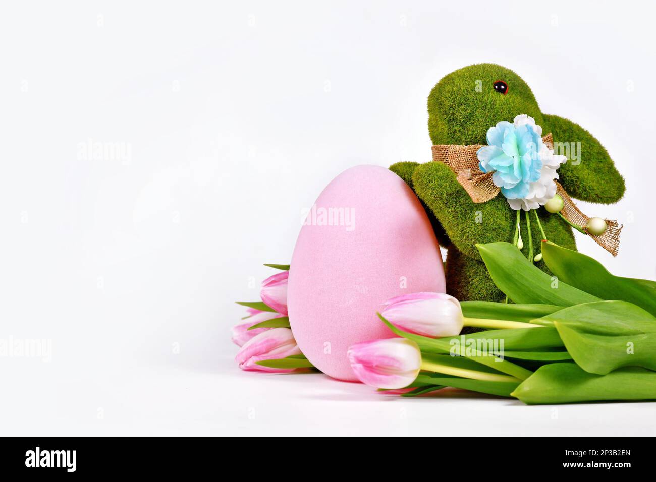 Conejito de Pascua de hierba, flores de tulipán y huevos pintados con espacio de copia Foto de stock