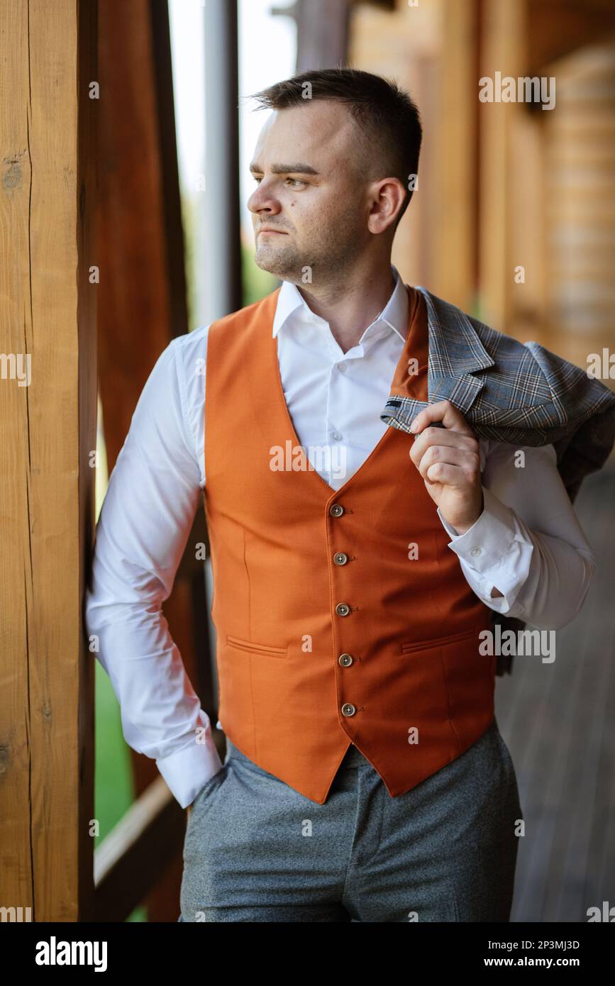 retrato del novio en un traje gris y un chaleco naranja y zapatillas  blancas Fotografía de stock - Alamy
