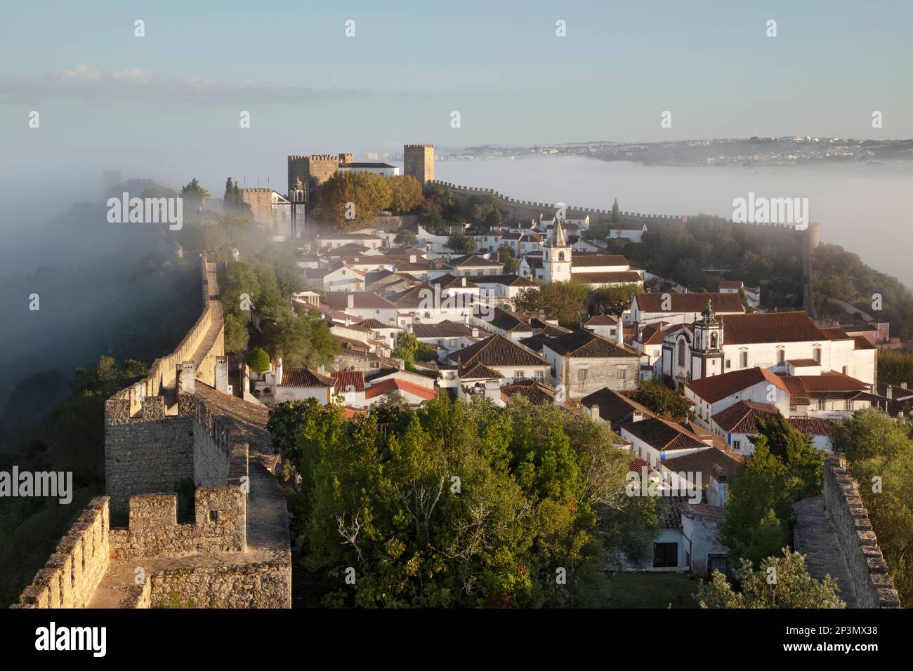 Vista sobre el casco antiguo y las murallas de Óbidos en la niebla de la mañana, Óbidos, Región Central, Portugal, Europa Foto de stock