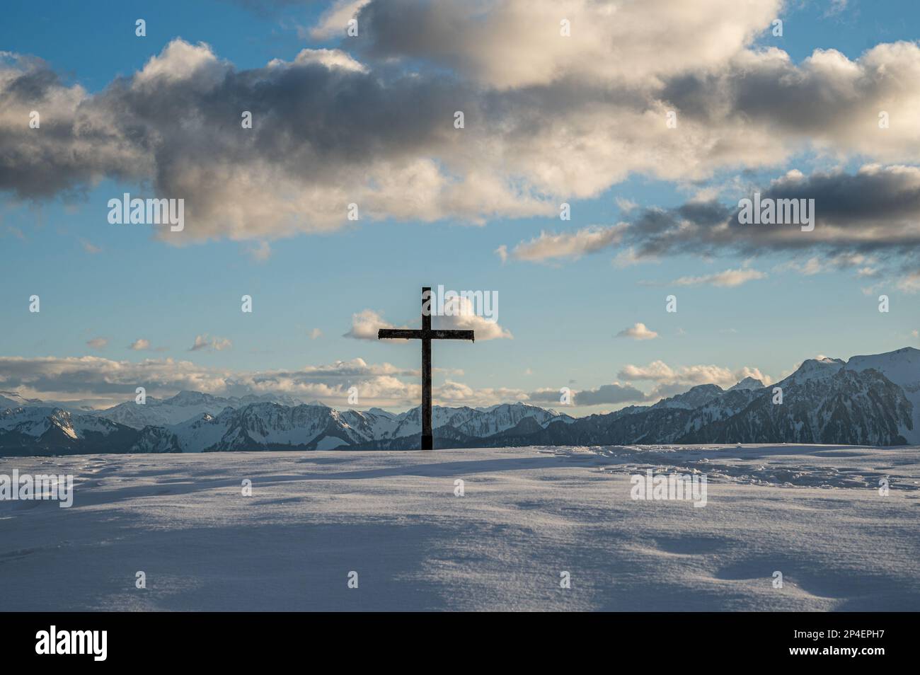 Cruce en la nieve. Cruz religiosa de madera en invierno. Les Pleiades, Suiza. Ambiente tranquilo. Foto de stock