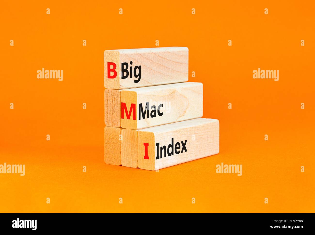 Símbolo de índice BIG mac de BMI. Palabras del concepto Índice grande del  mac de BMI en bloques de madera sobre un fondo naranja de la tabla hermosa.  Negocios y BMI big