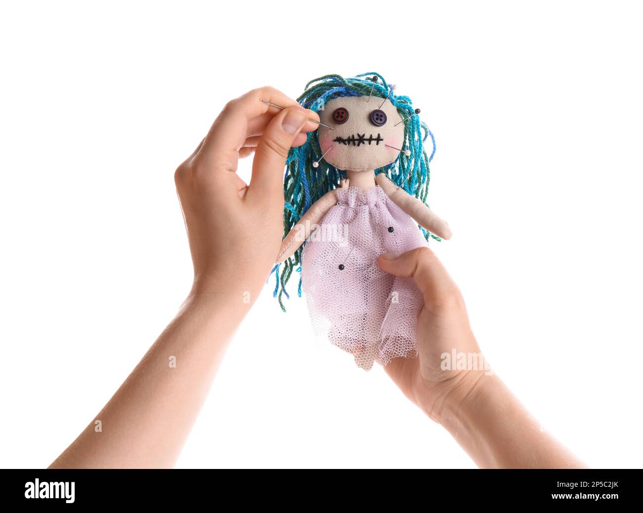 Mujer apuñalando muñeca vudú con alfiler sobre fondo blanco, closeup. Ceremonia de la maldición Foto de stock