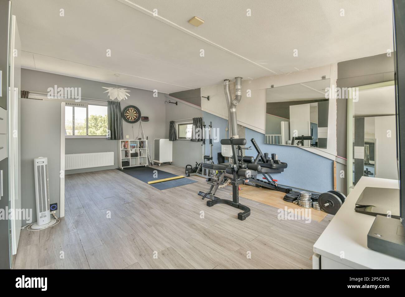 una sala de gimnasio en casa con espejos en la pared y una bicicleta  estática en el centro de la habitación está vacía Fotografía de stock -  Alamy