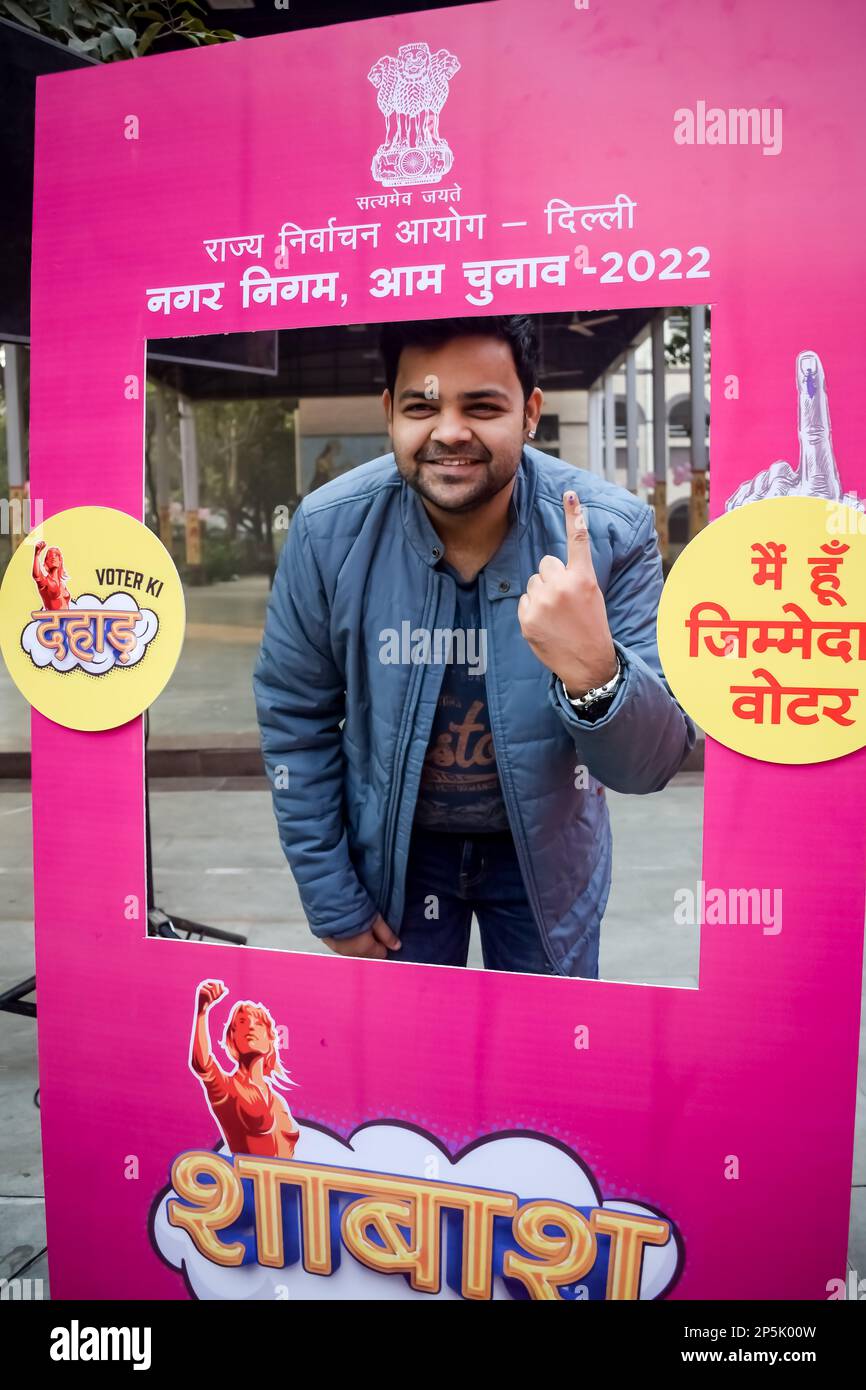 Nueva DELHI, INDIA - 04 2022 de diciembre - Personas no identificadas mostrando sus dedos marcados con tinta después de emitir votos frente a la cabina de votación del este de Delhi Foto de stock