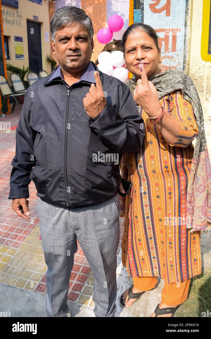 Nueva DELHI, INDIA - 04 2022 de diciembre - Personas no identificadas mostrando sus dedos marcados con tinta después de emitir votos frente a la cabina de votación del este de Delhi Foto de stock