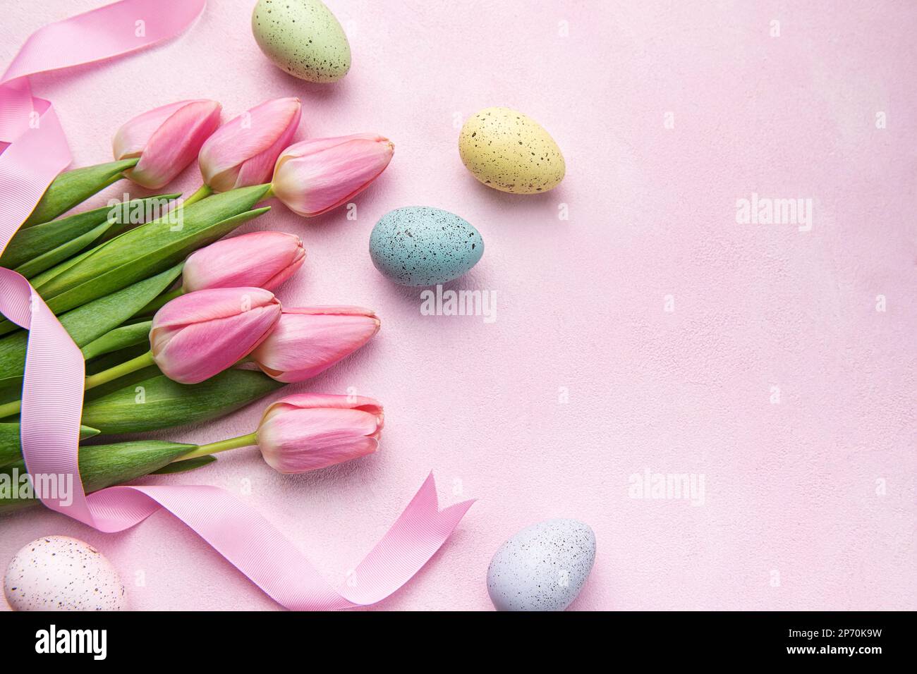 Tarjeta de felicitación para las vacaciones de pascua. Ramo de tulipanes rosados y huevo de Pascua sobre fondo rosa. Espacio para texto Foto de stock