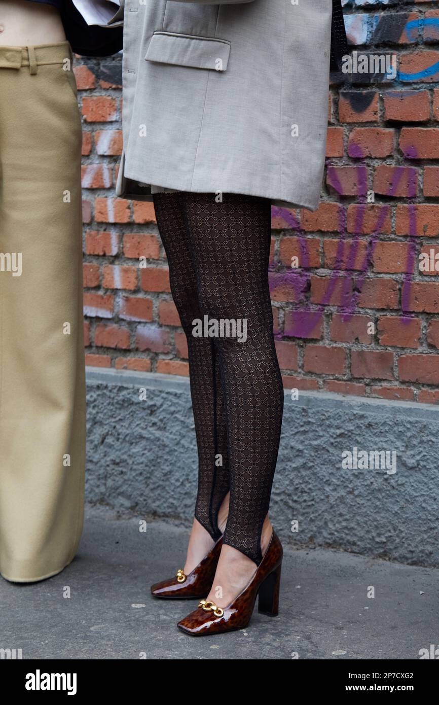 MILÁN, ITALIA - 22 DE FEBRERO de 2023: Mujer con medias negras de estribo antes del desfile de Fendi, estilo callejero de la Semana de la Moda de Milán Foto de stock