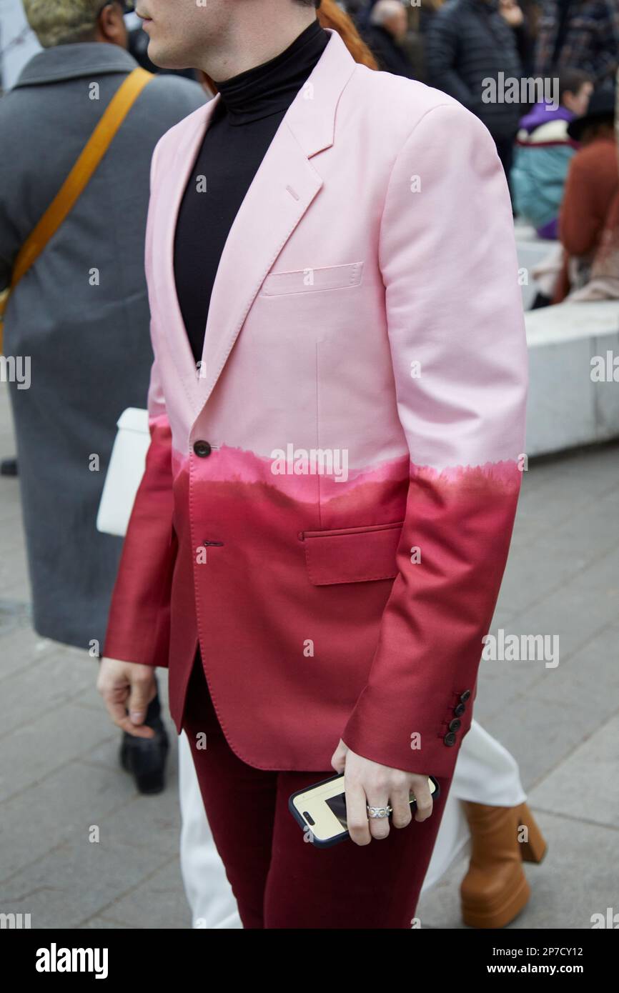MILÁN, ITALIA - 22 DE FEBRERO de 2023: Hombre con chaqueta mitad rosa y rojo oscuro y cuello alto negro antes del desfile de Alberta Ferretti, Milan Fashion Week Foto de stock