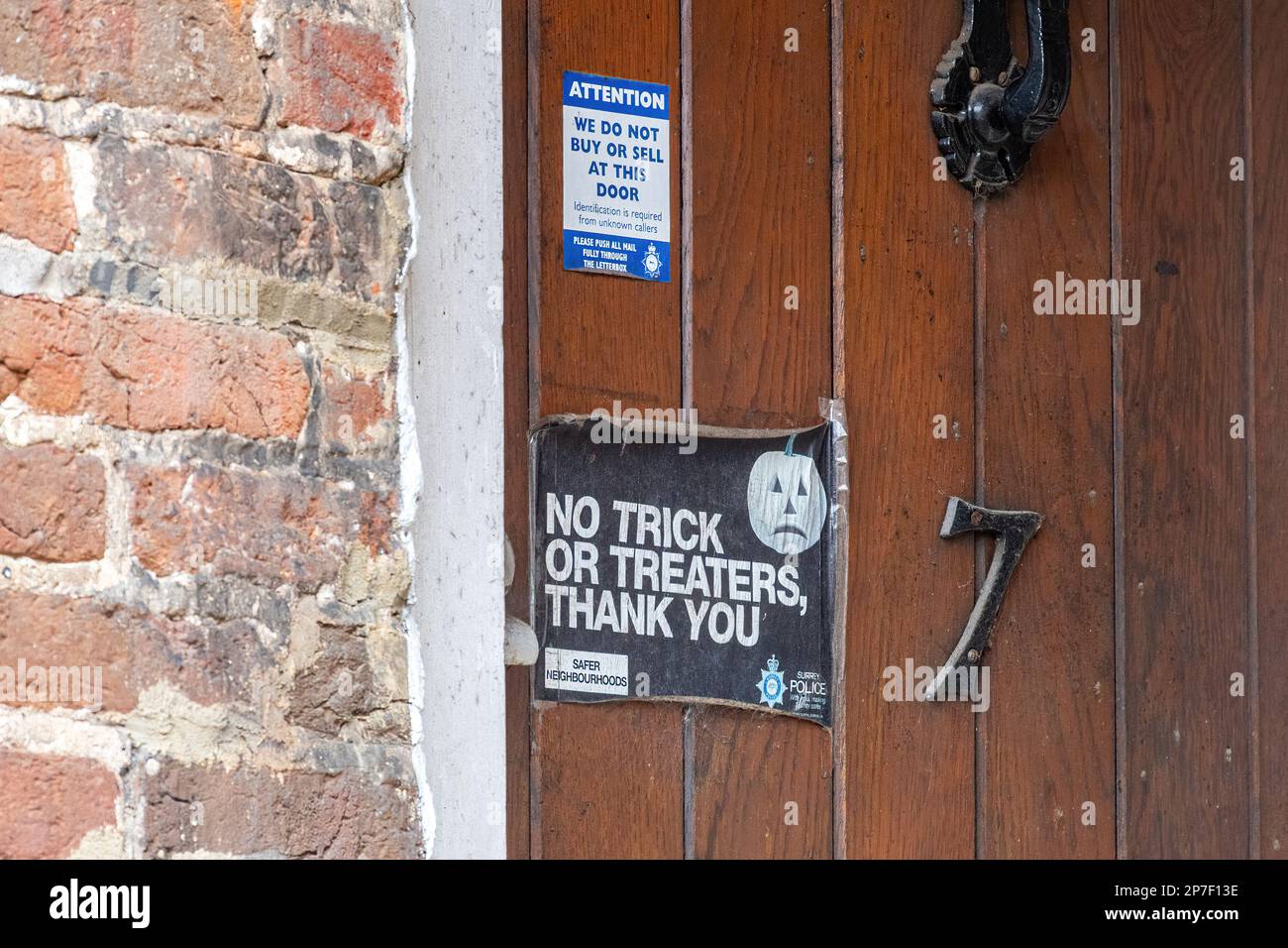 Pegatinas de policía de Surrey en una puerta principal que dice 'No Trick or Treaters' y 'No compramos o vendemos en esta puerta', seguridad en el hogar para personas vulnerables, Reino Unido Foto de stock