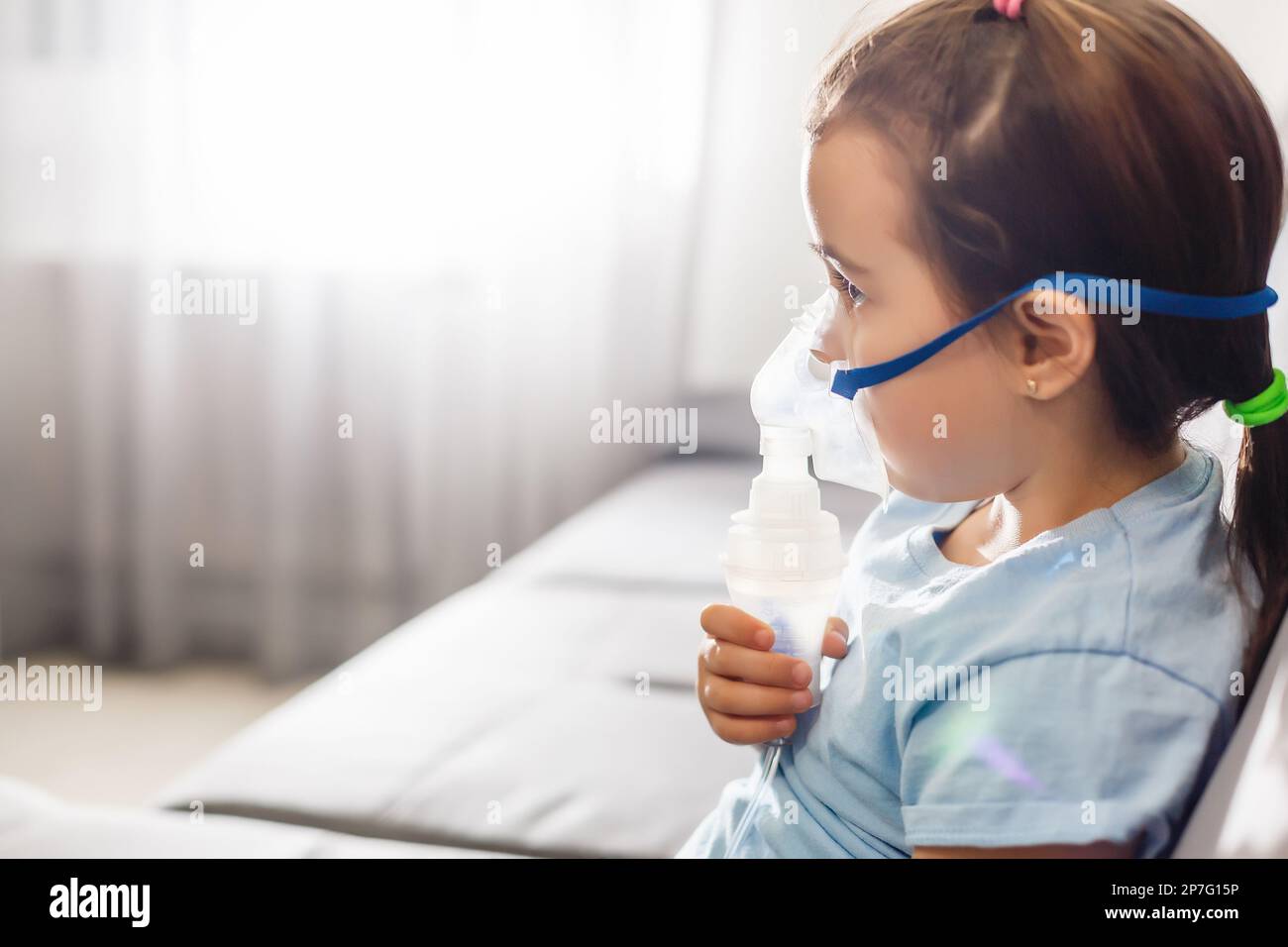 Niñito en una máscara, tratamientos del tracto respiratorio con un  nebulizador en casa. El bebé se sienta con un nebulizador en su boca,  inhalador, tratamiento de bronquitis Fotografía de stock - Alamy