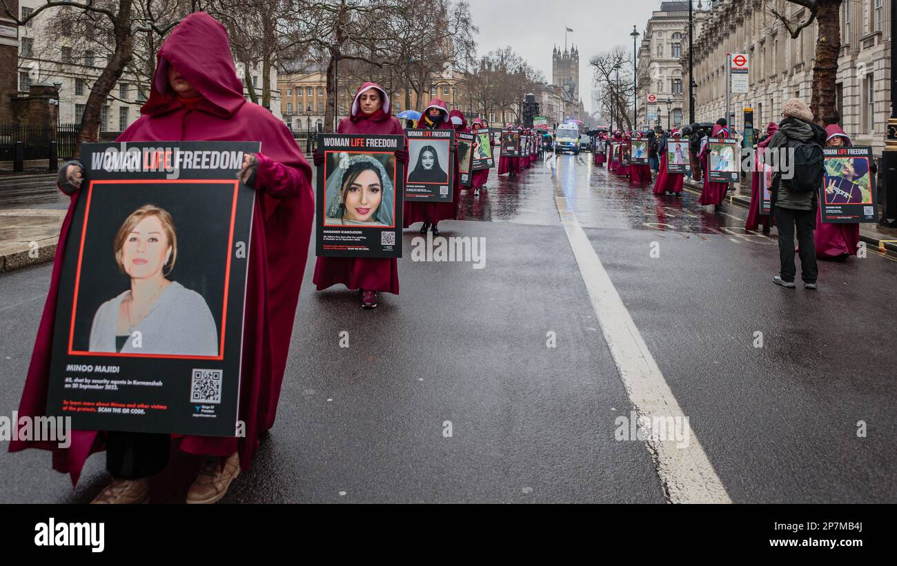 Marchando en Whitehall, las mujeres británicas-iraníes se vistieron como personajes de The Handmaid's Tale en el Día Internacional de la Mujer 2023. Foto de stock