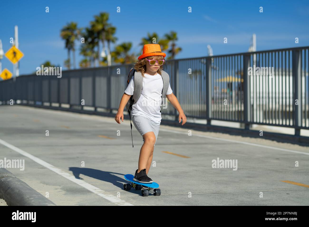 Niños deportivos de verano con skateboard. Niño montando skateboard en la  carretera. Niño practicando skateboard. Los niños aprenden a montar en  patineta en un parque Fotografía de stock - Alamy