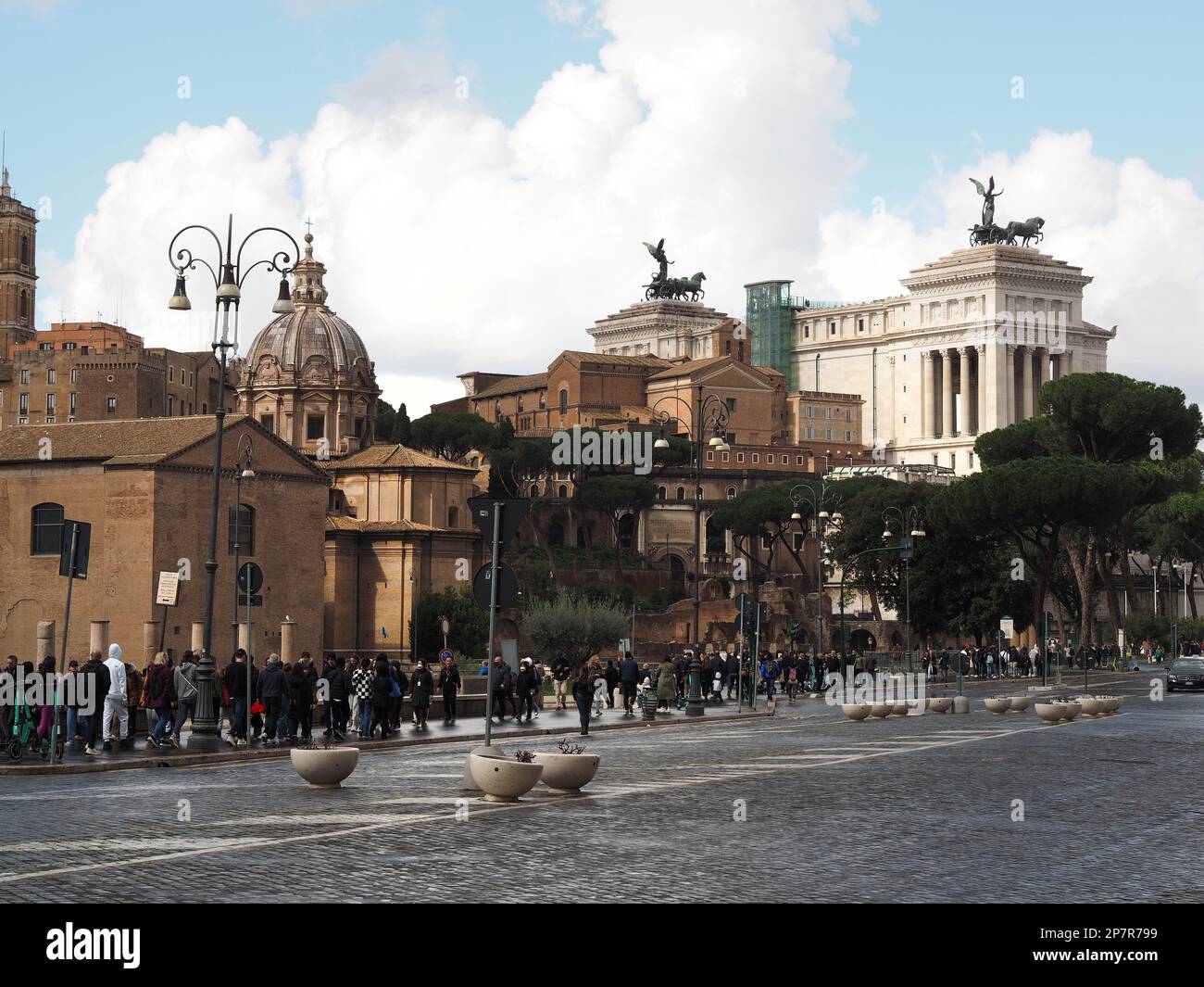 Via dei fori imperiali en el centro histórico de la ciudad de Roma, Italia, con muchos turistas caminando en la acera. Foto de stock