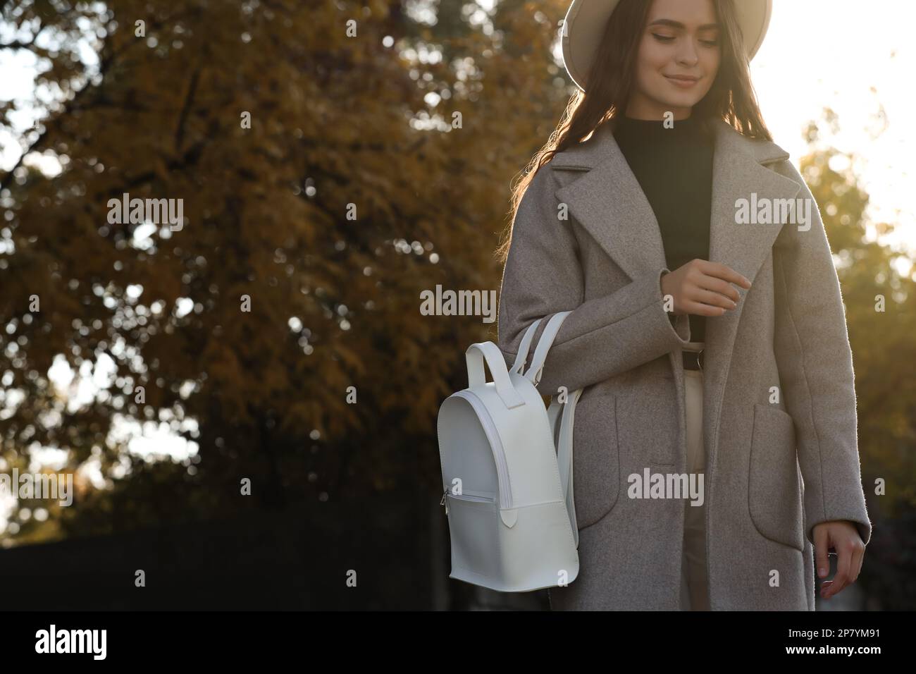 Mujer joven con la mochila blanca elegante en el parque, espacio para el  texto Fotografía de stock - Alamy