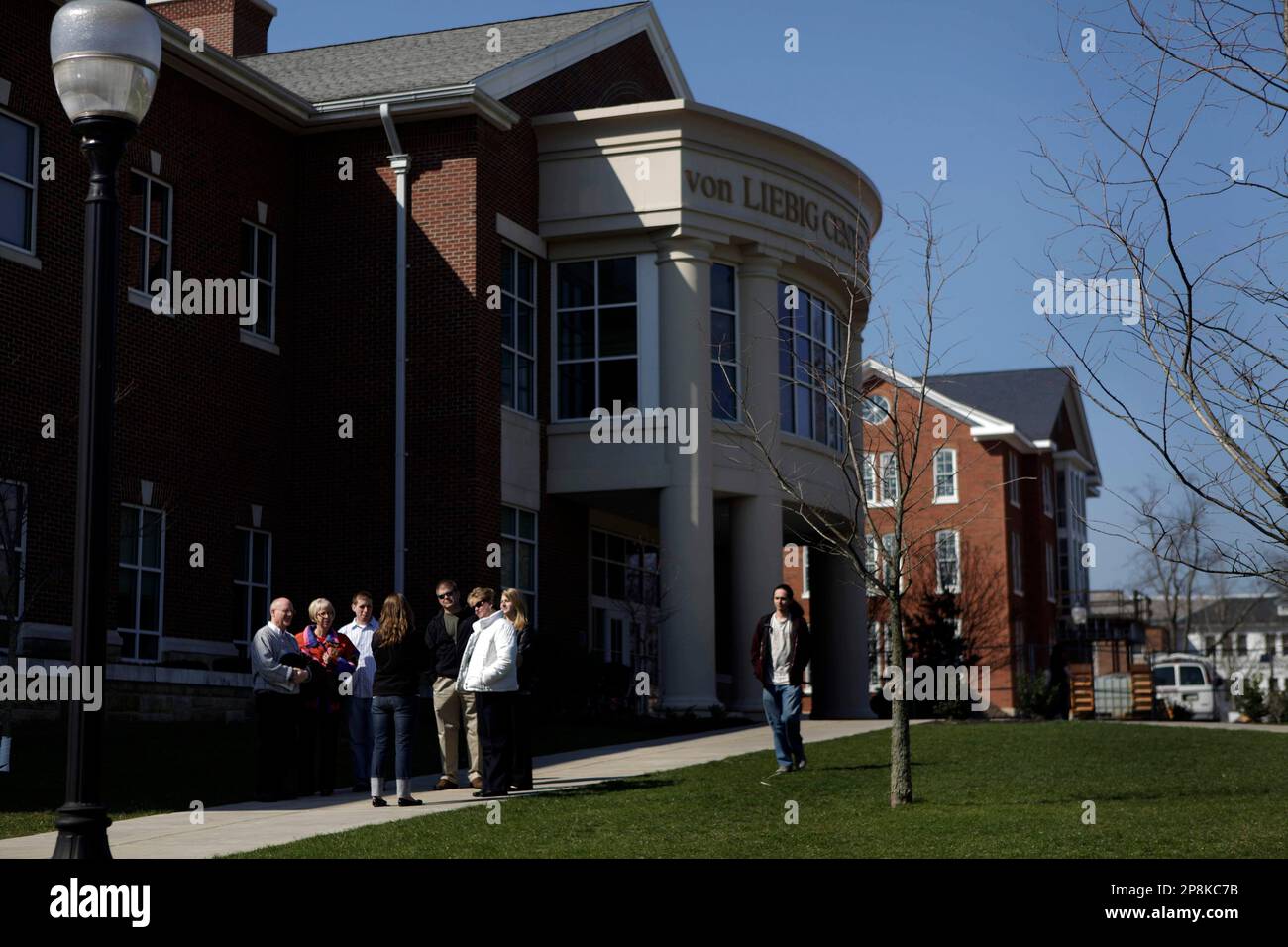 Prospective students and their parents, the group at left, pause during