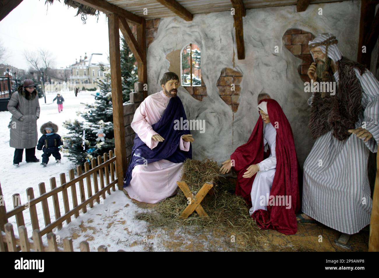 People walk near a Nativity scene outside the Cathedral of the