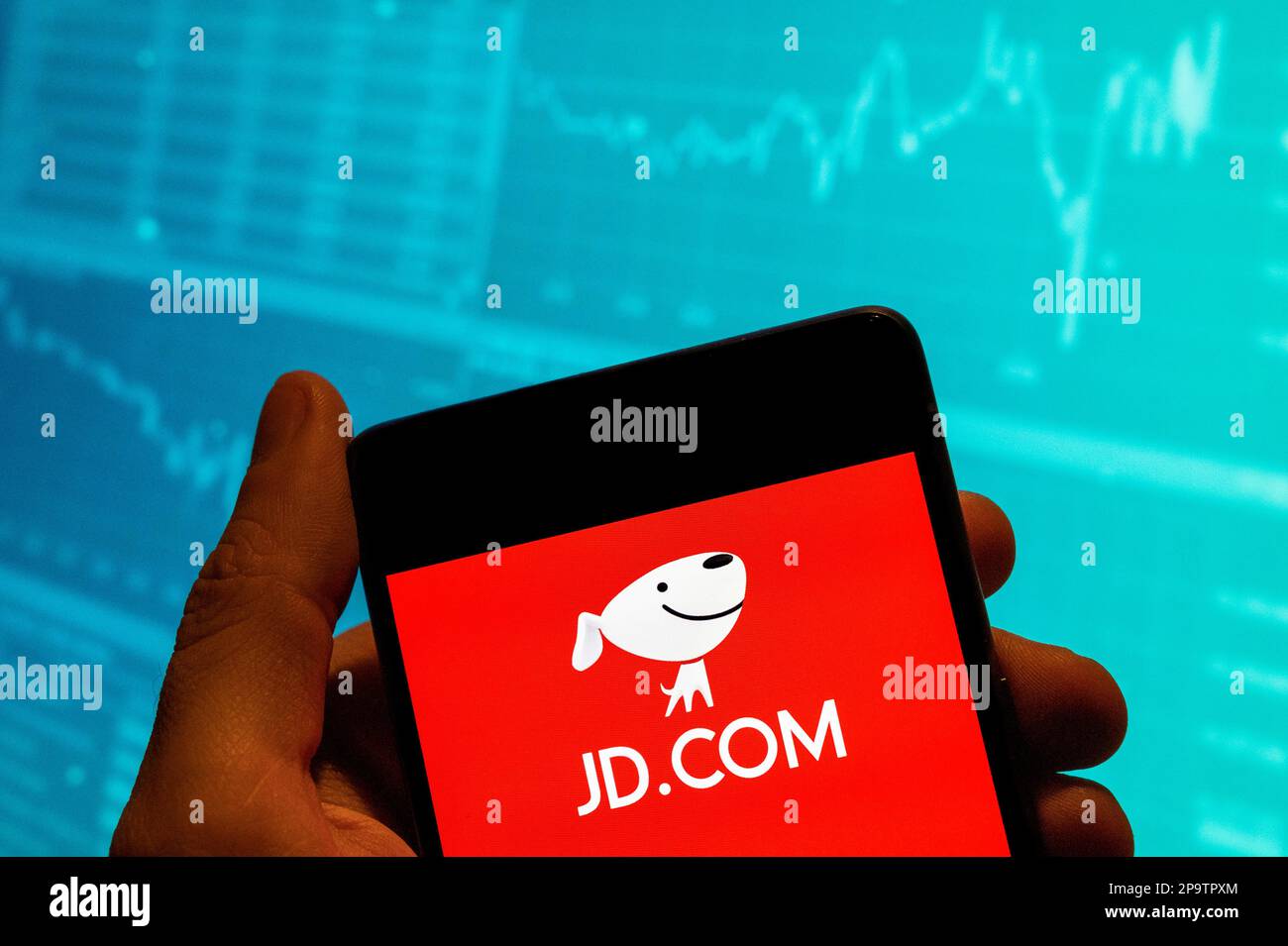 En esta ilustración de la foto, el logotipo de la empresa de comercio  electrónico china JD.com se muestra en un teléfono inteligente con un  gráfico de índice de bolsa económica en el