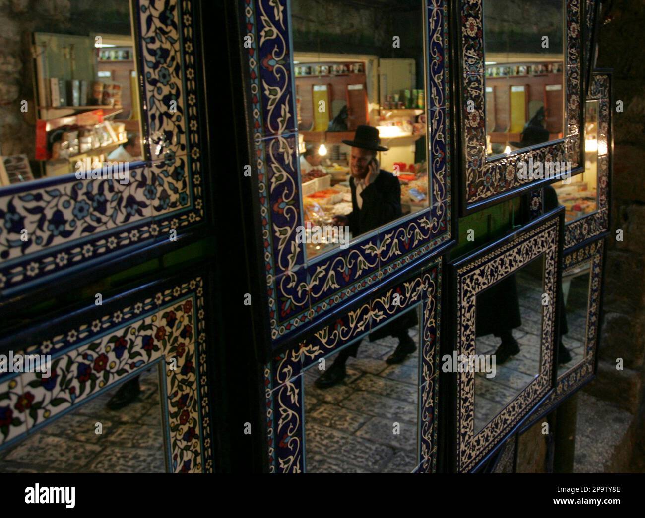 An UltraOrthodox Jewish man is reflected in mirrors in the market in