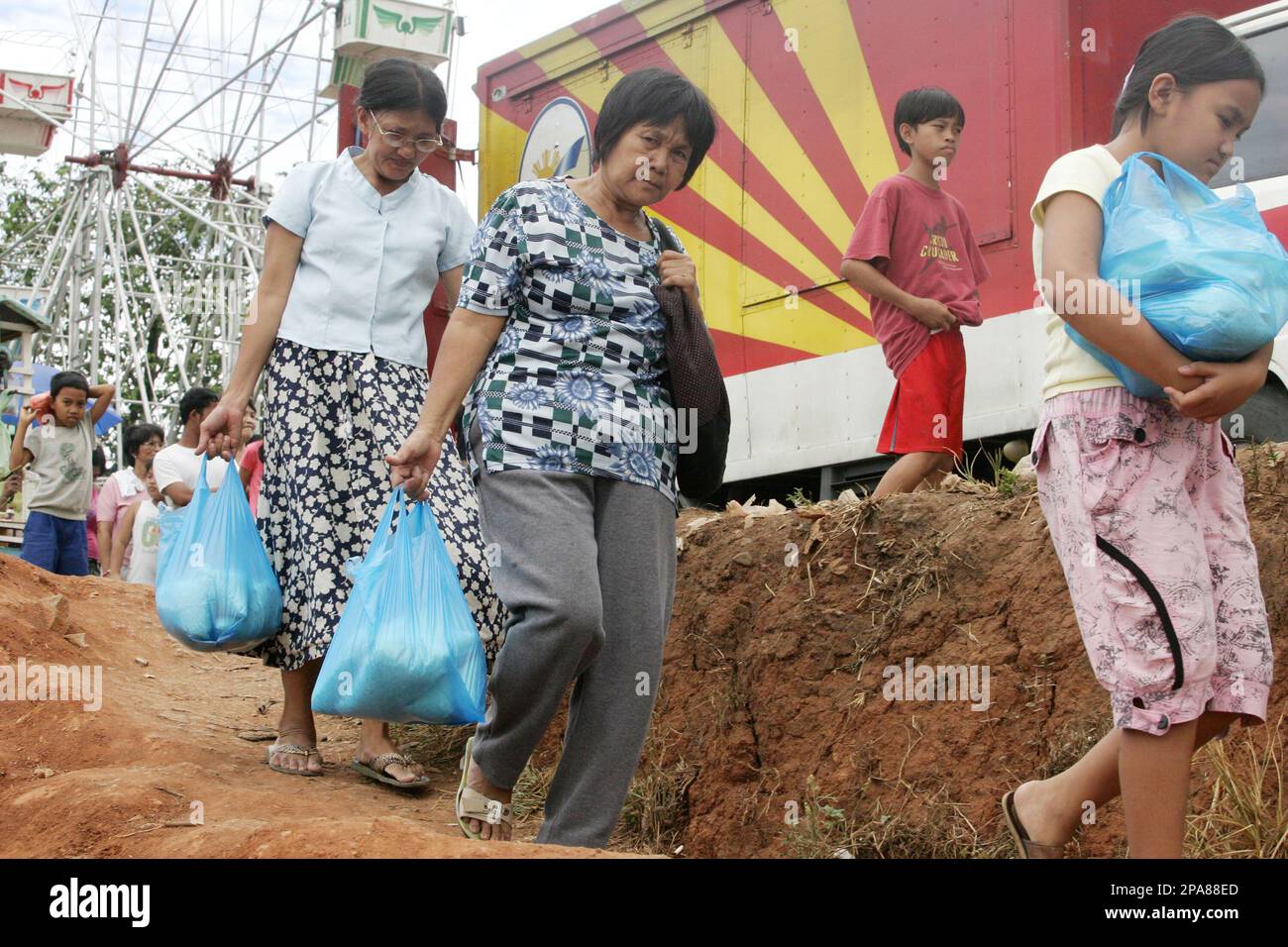 People walk back home after buying the cheapest rice available in the