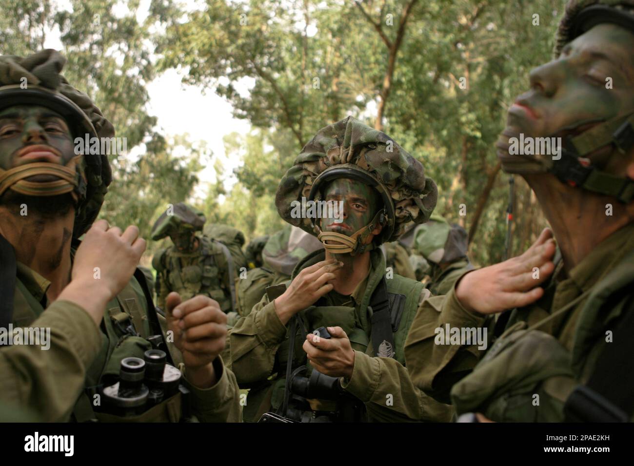Israeli soldiers paint their faces before going out on patrol along the