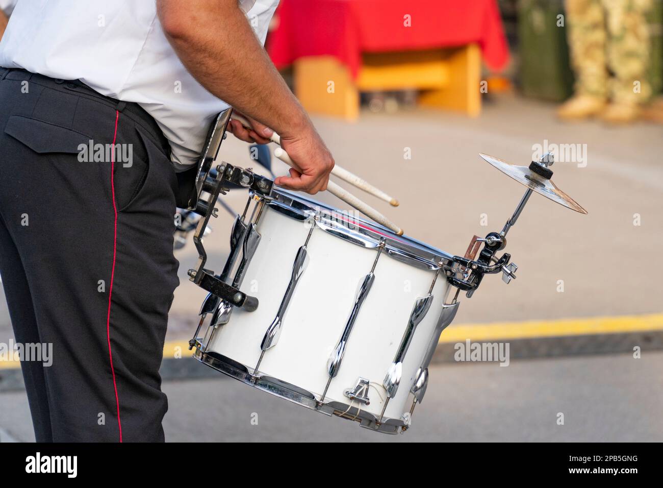 El baterista de una banda militar toca un tambor portátil Foto de stock