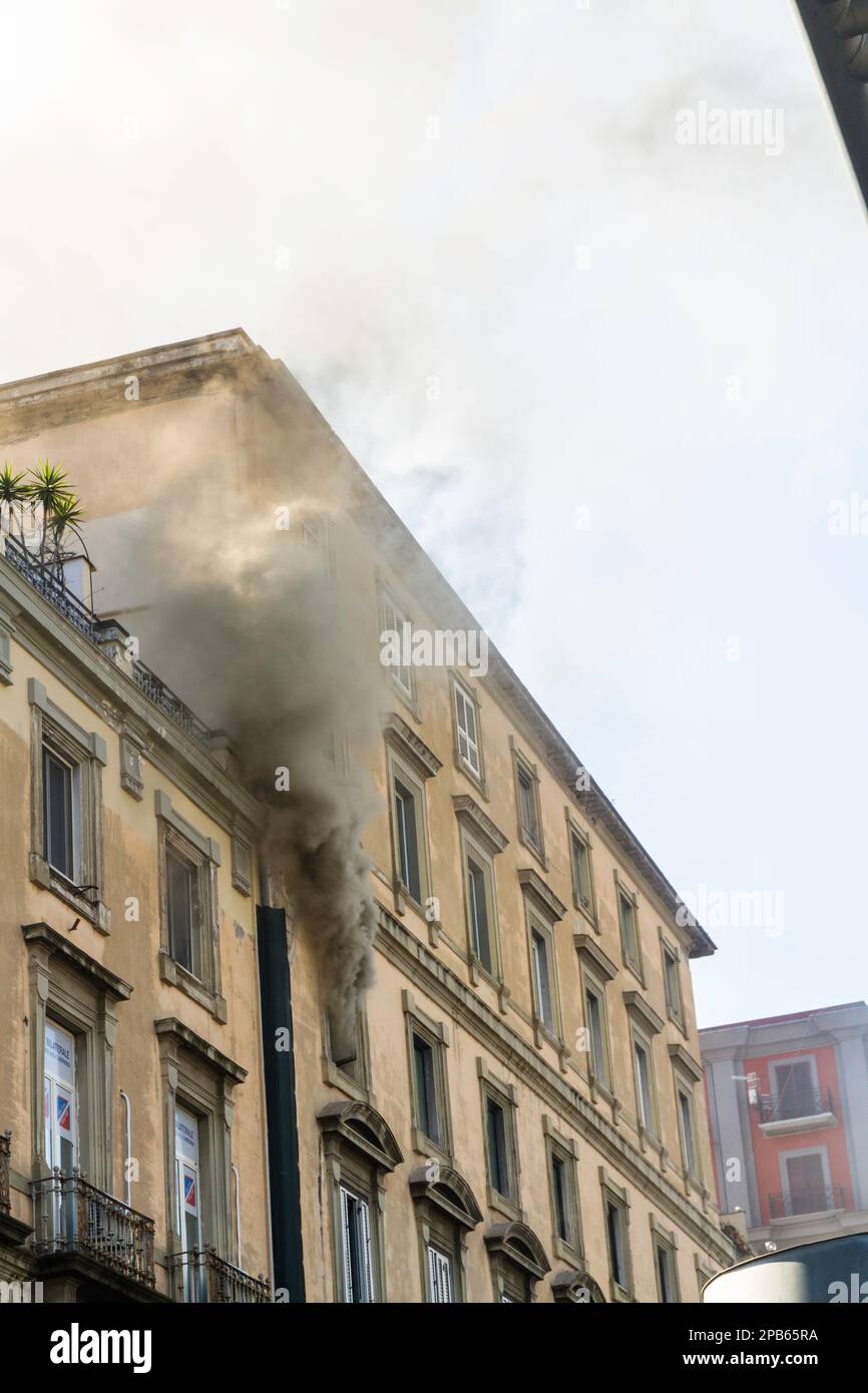 Nápoles, Italia - Febrero 15th 2023 - Fuego doméstico del apartamento con el humo que brota de la ventana de arriba. Plaza Garibaldi, Nápoles, Italia, retrato Foto de stock