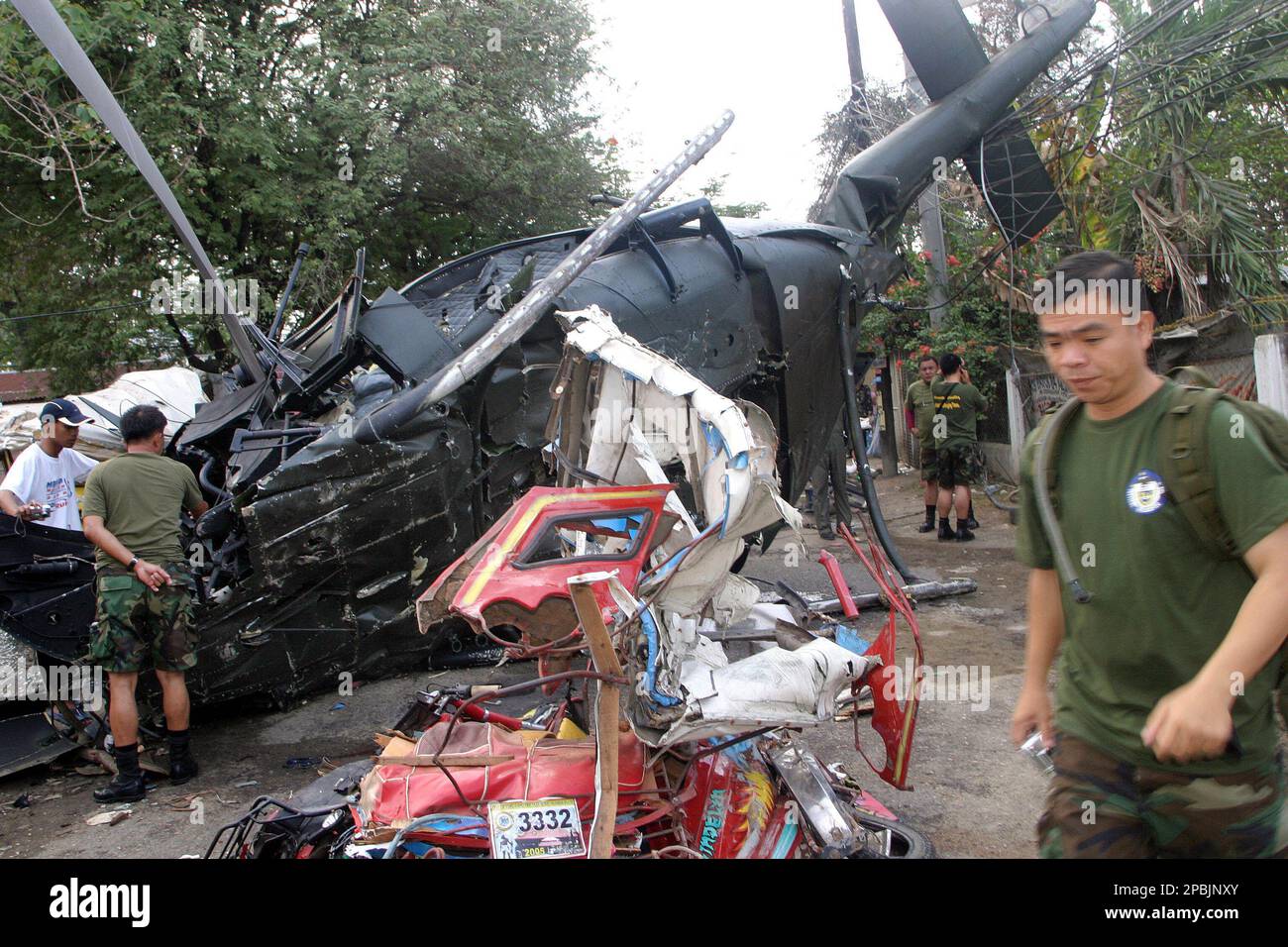 Personnel from Philippine Air Force walk around the remains of a Vietnam warera military Huey