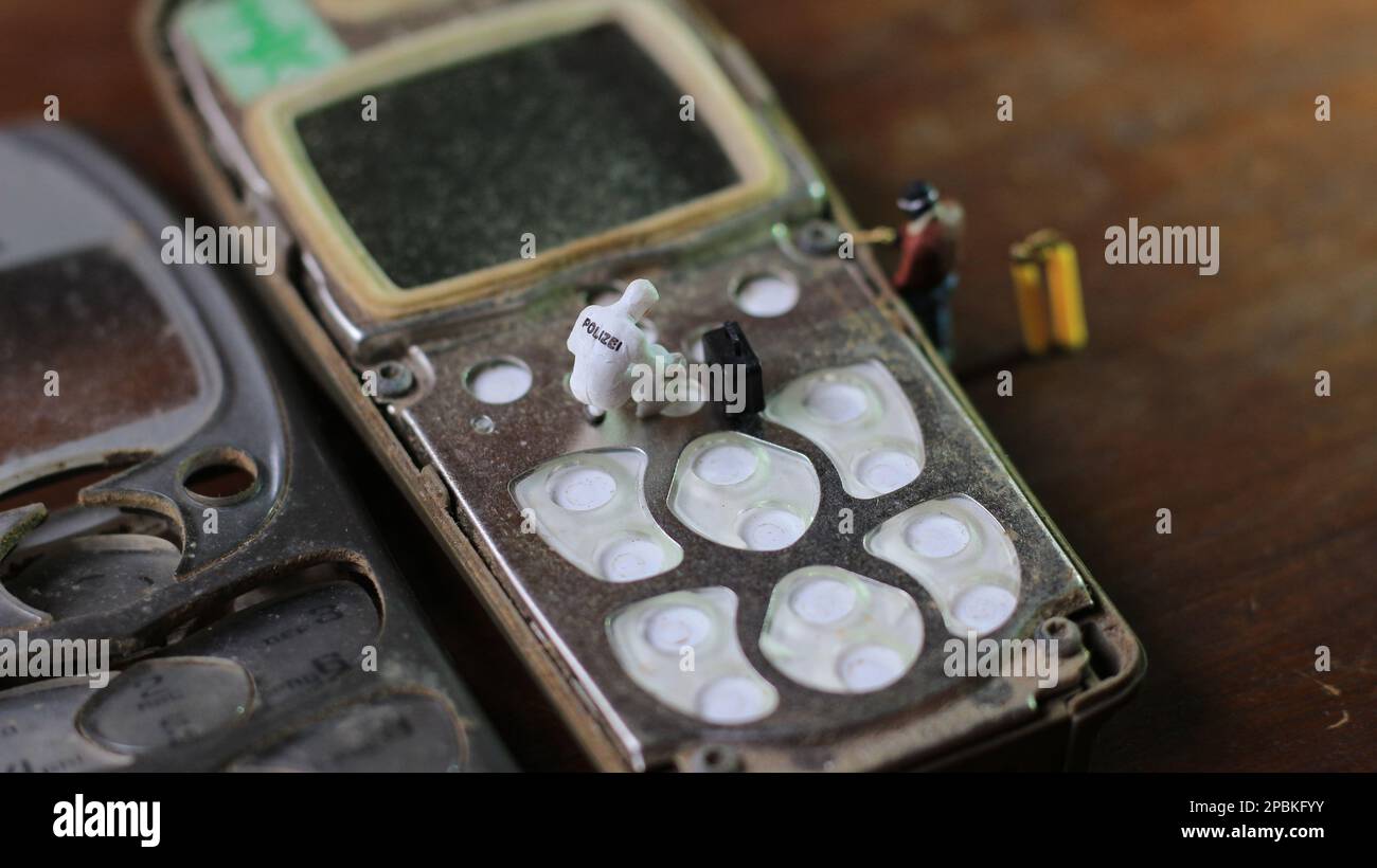 figura miniatura de un técnico reparando un viejo teléfono celular roto.  concepto de técnico de trabajo Fotografía de stock - Alamy