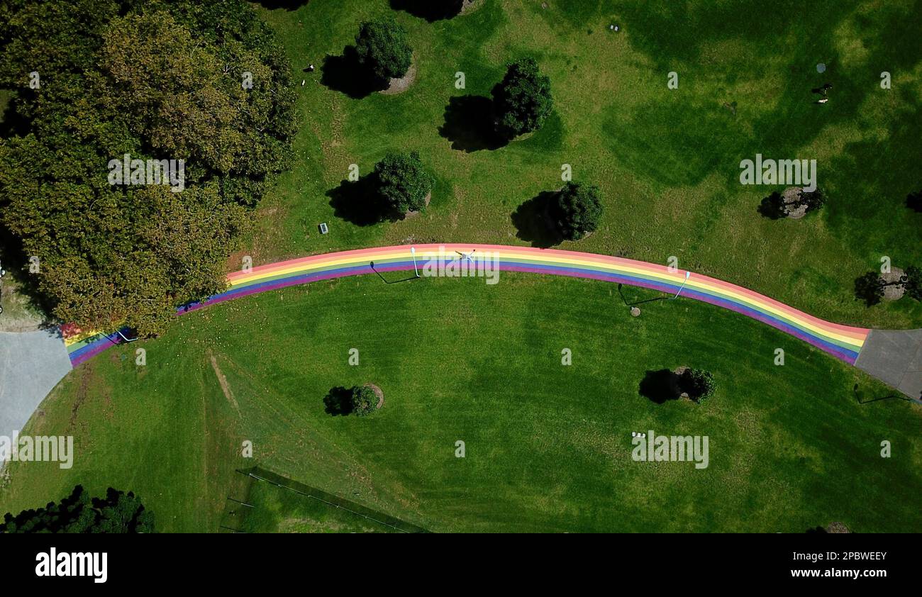 Vista aérea de un hombre acostado en medio de un arco iris. Foto de stock