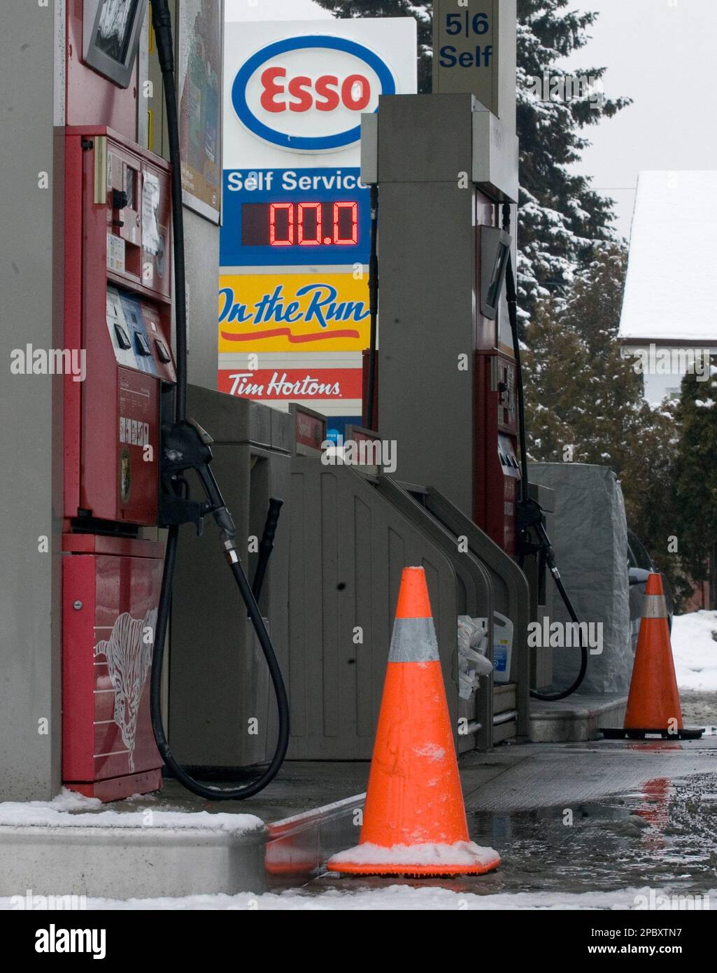 A cone sits in front of an empty gas pump at an Esso gas station which
