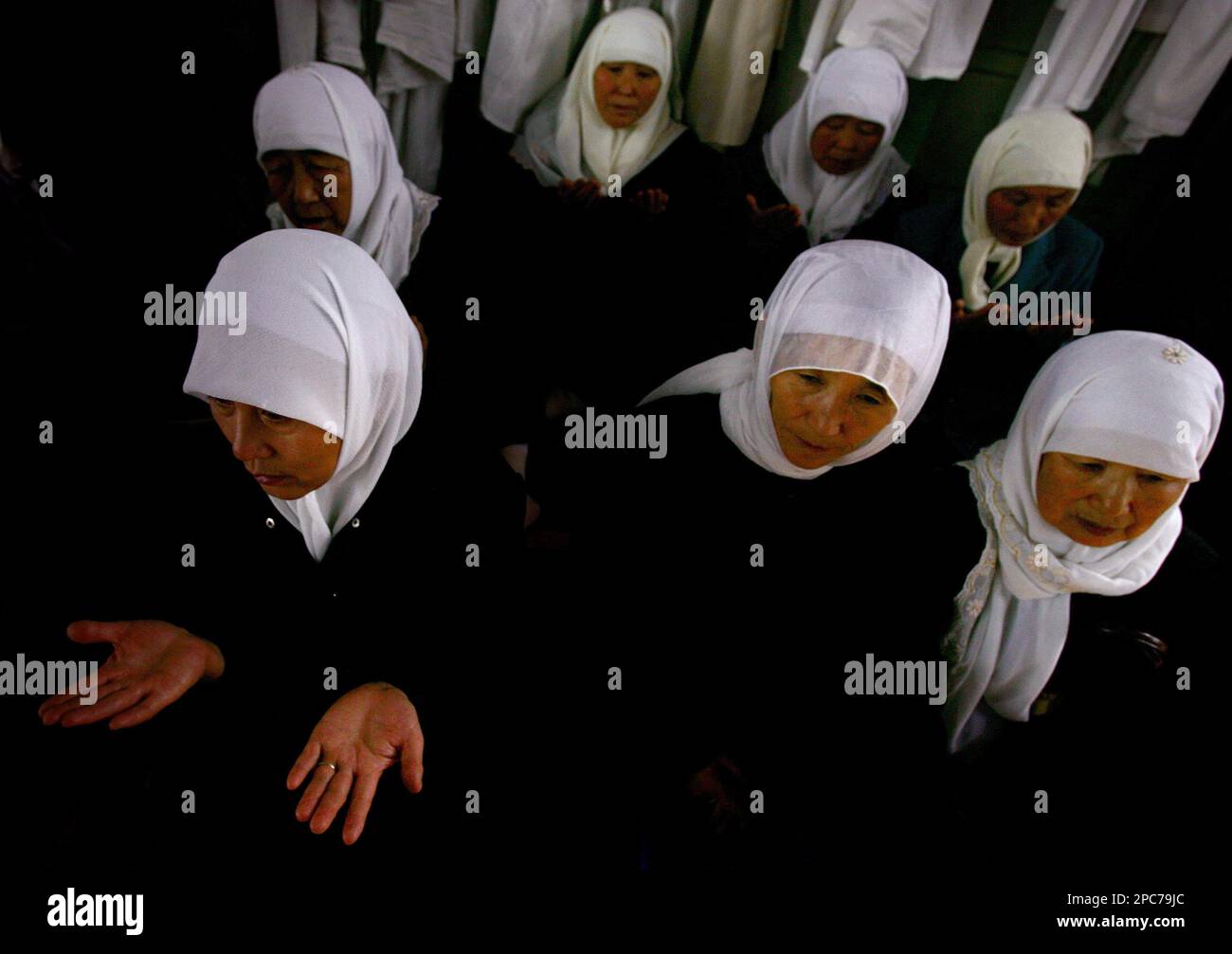 Muslim women pray during the graduation ceremony of male imams in the