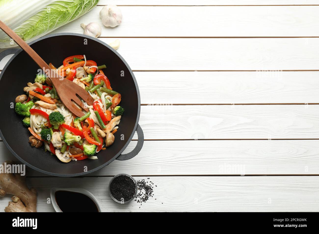 Revuelva los fideos fritos con champiñones, pollo y verduras en wok en la  mesa de madera blanca, llano. Espacio para texto Fotografía de stock - Alamy