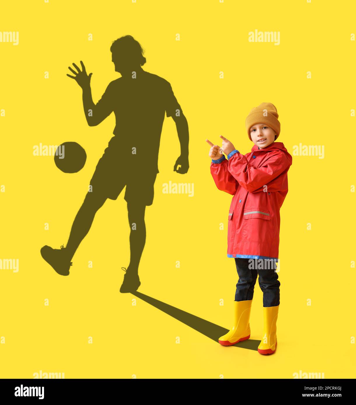 Niño pequeño con la pelota de fútbol sobre fondo amarillo Fotografía de  stock - Alamy