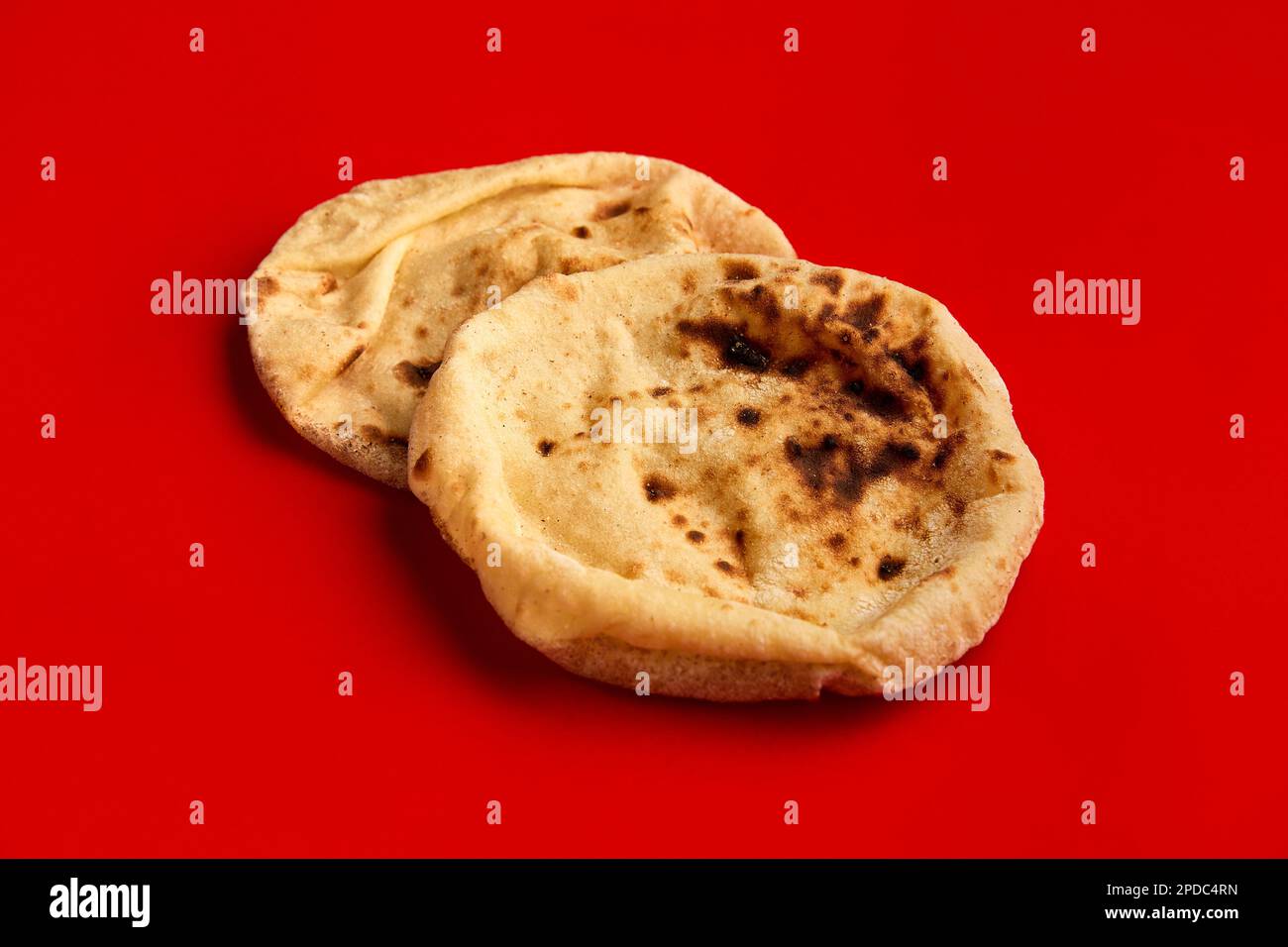 Pan egipcio Aish Baladi. Un montón de pan fresco yace en la mesa roja  Fotografía de stock - Alamy