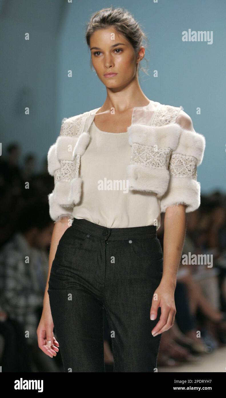 A pearl mink bolero with white beaded trim is modeled with a white chiffon  tank top and denim capri jeans during the presentation of the spring 2006  collection of J. Mendel in