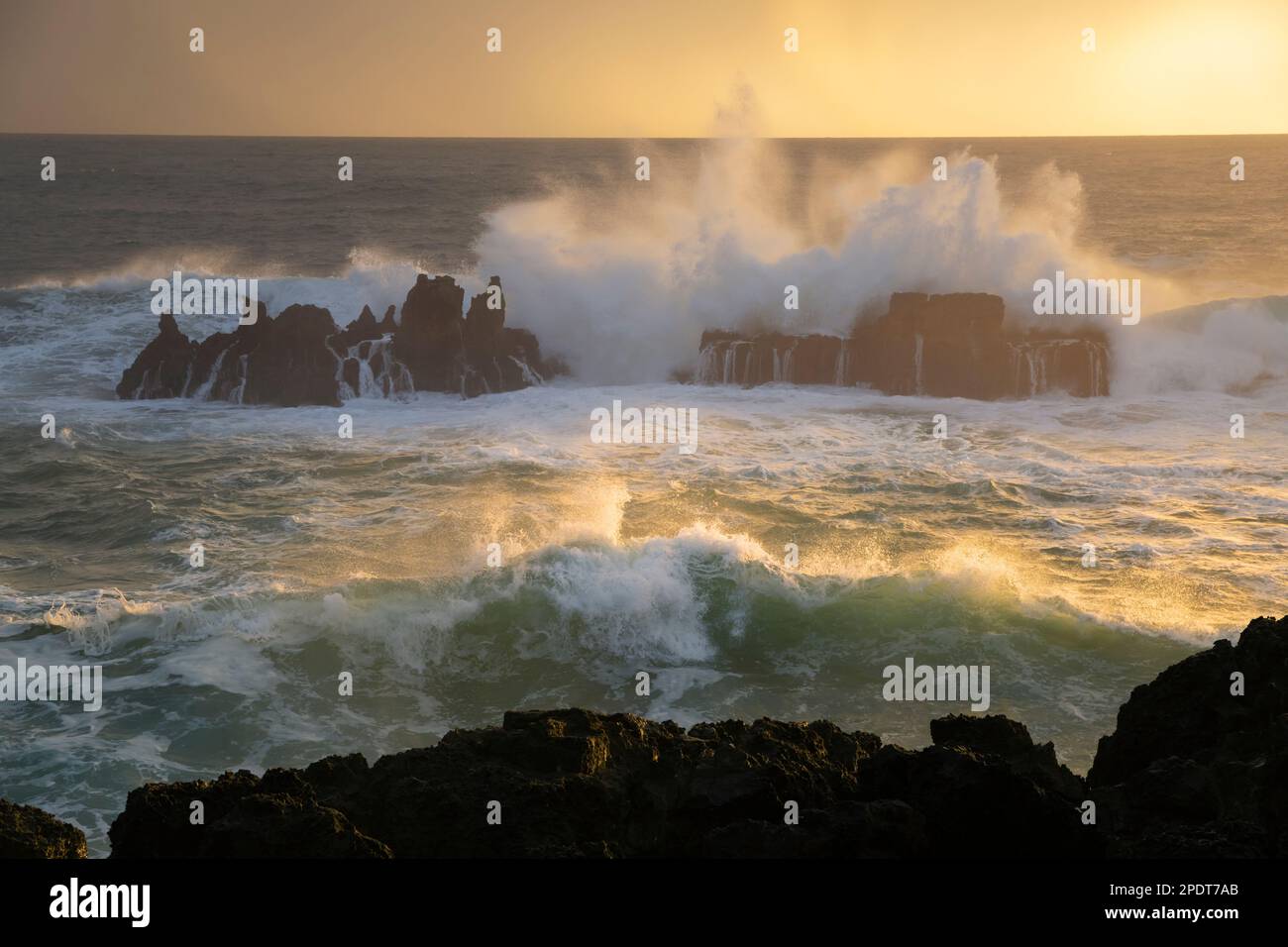 Olas del Océano Atlántico estrellándose sobre rocas en Campos de Lapias al atardecer, Cascais, Región de Lisboa, Portugal, Europa Foto de stock