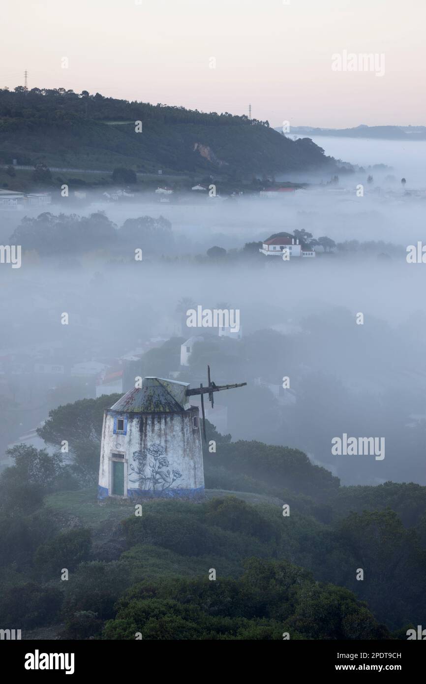 En ruinas Moinho do Facho molino de viento en el campo en la niebla de la mañana, Óbidos, Región Central, Portugal, Europa Foto de stock