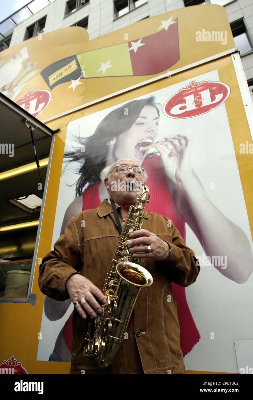 A man plays his saxophone next to a frituur stand during an attempt at