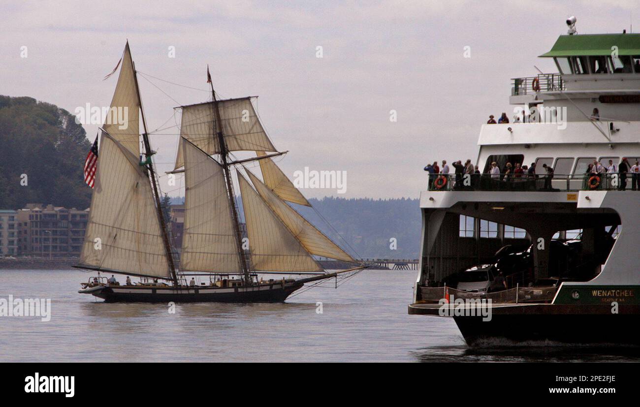 Passengers aboard the state ferry Wenatchee, right, get a close look at the passing tall ship