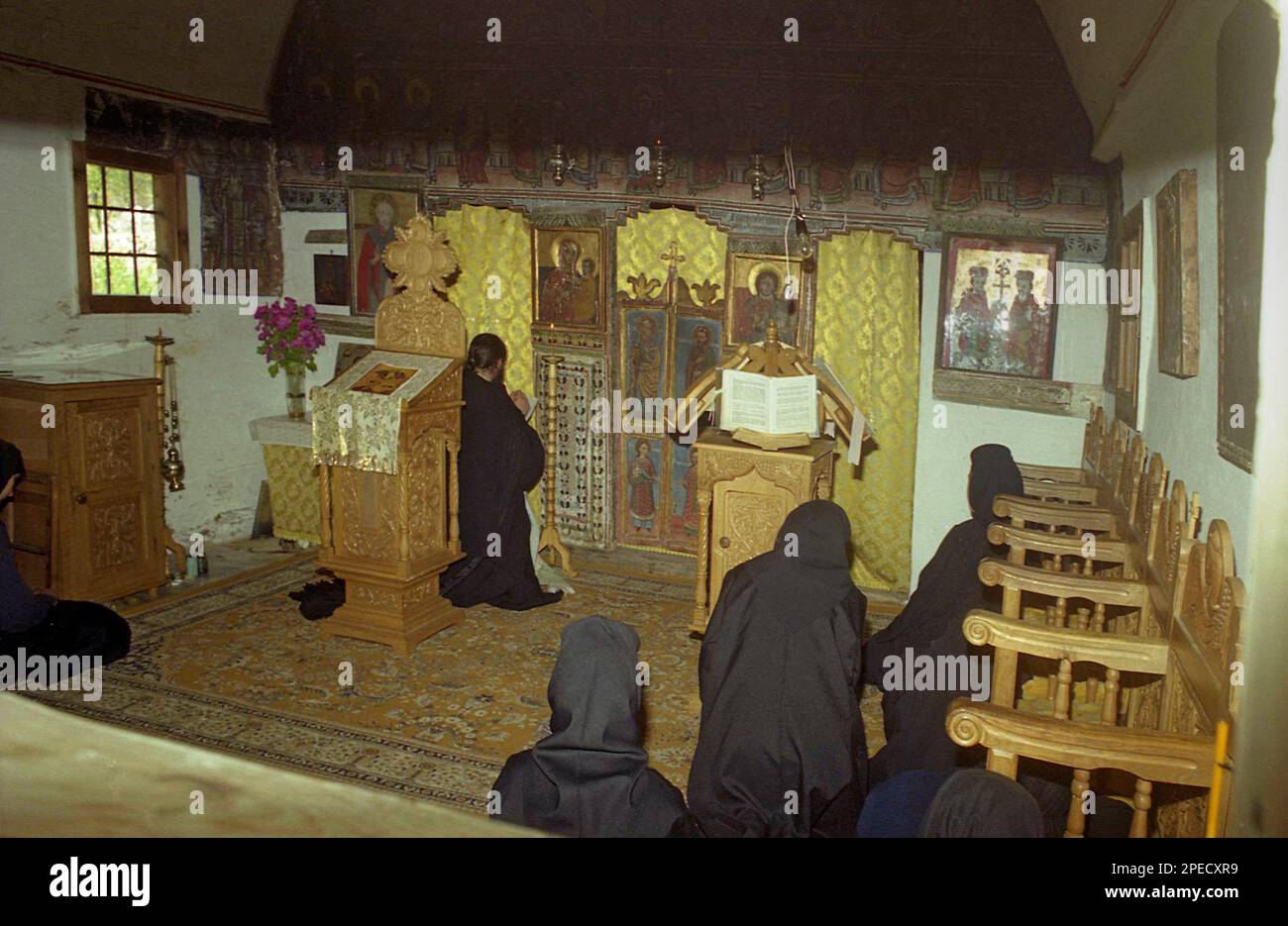 Monasterio Sub Piatra, Condado de Alba, Rumania, 2001. Monjas y sacerdotes orando durante el servicio religioso en la iglesia de madera del siglo 18th. Foto de stock