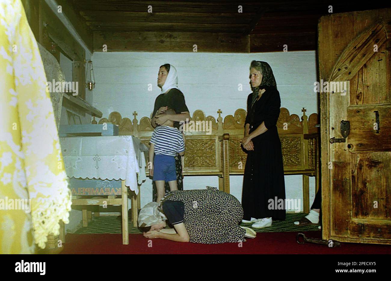 Monasterio Sub Piatra, Condado de Alba, Rumania, 2001. Creyentes rezando dentro de la vieja iglesia de madera. Foto de stock