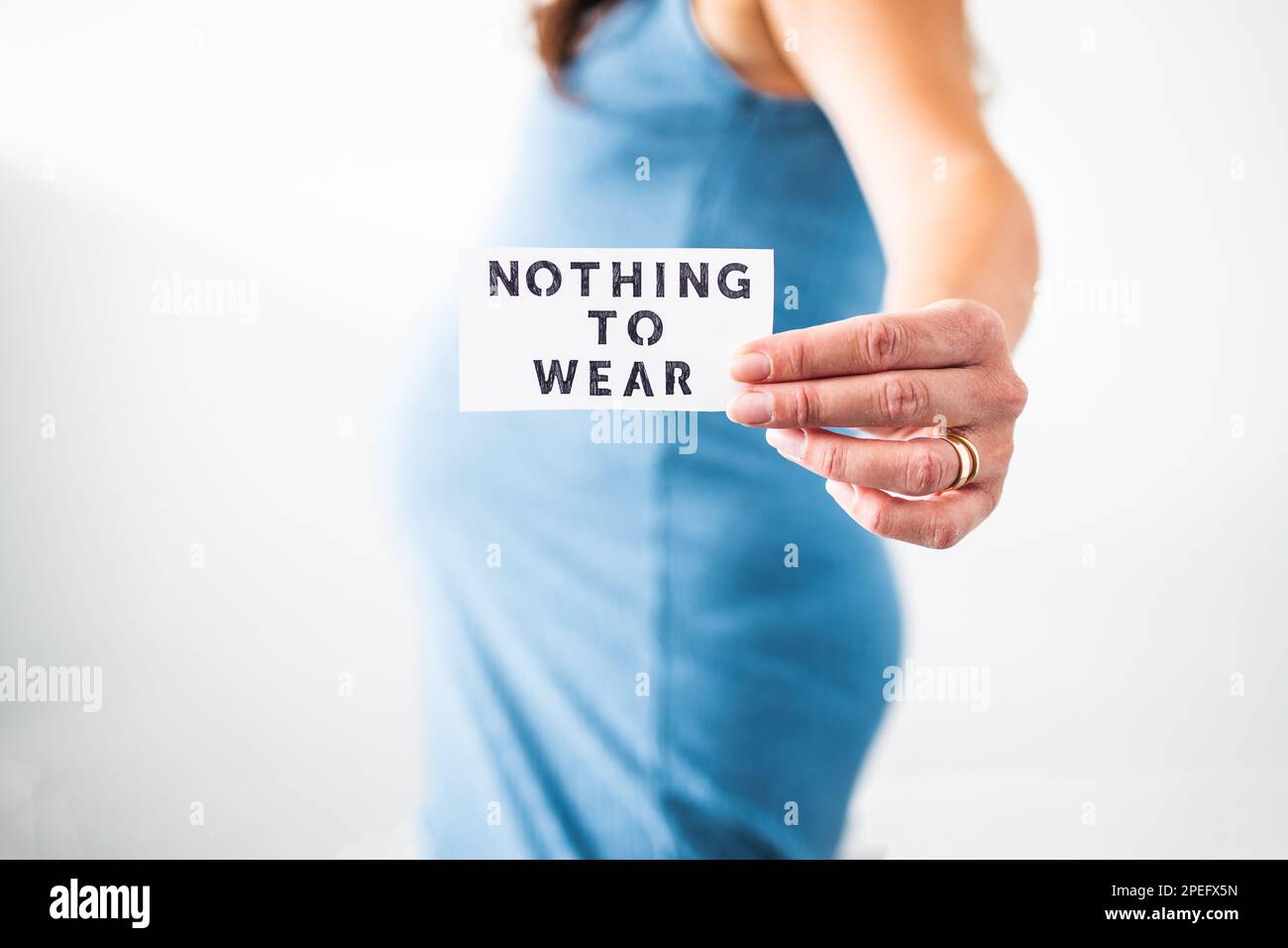 No hay nada que llevar signo sostenido por la mujer embarazada en el último  mes de embarazo con vestido azul elástico que muestra su bulto, ropa de  maternidad e inclusivo Fotografía de