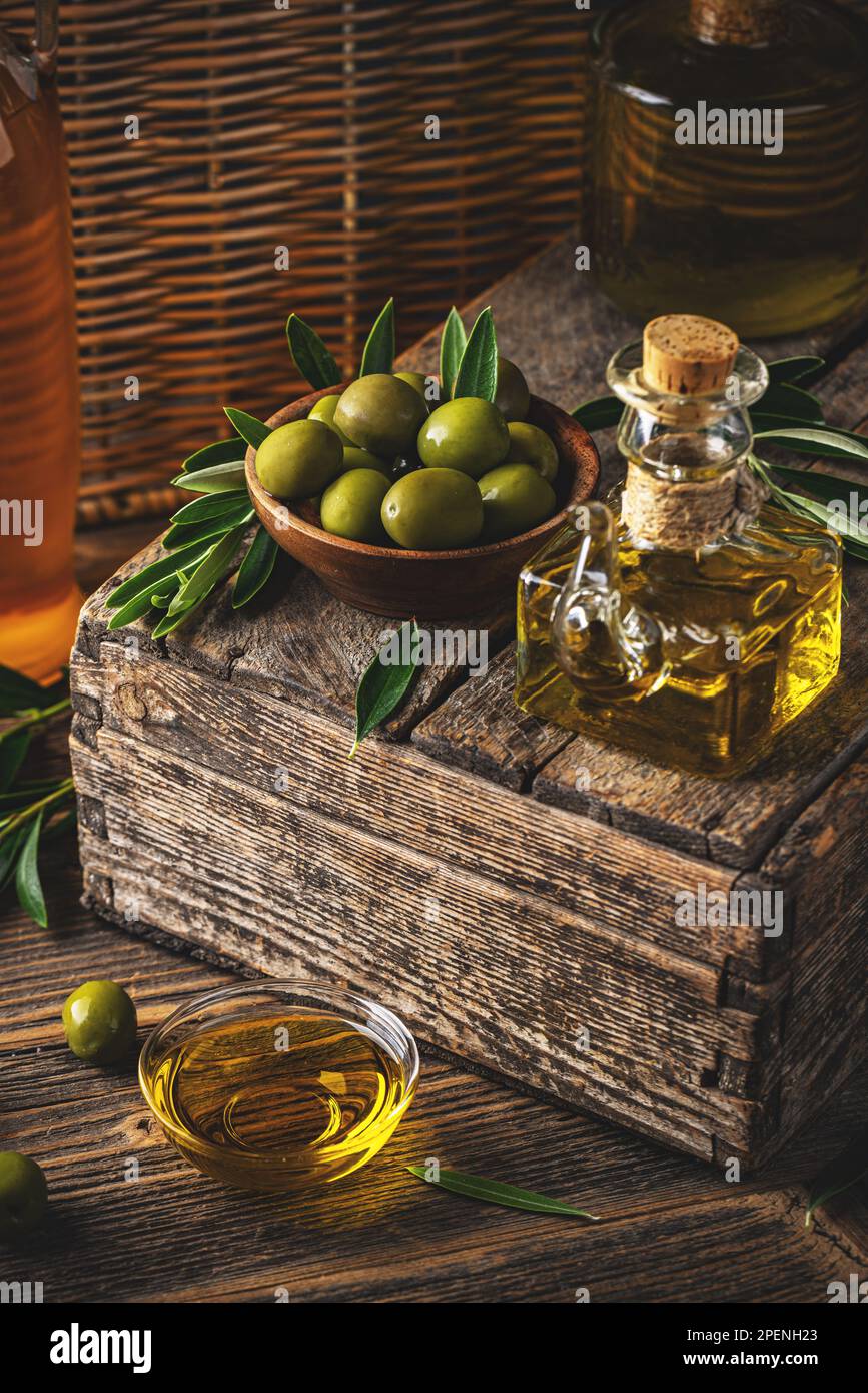 Las aceitunas siguen la vida, el aceite de oliva saludable y las aceitunas en el fondo de estilo rústico Foto de stock
