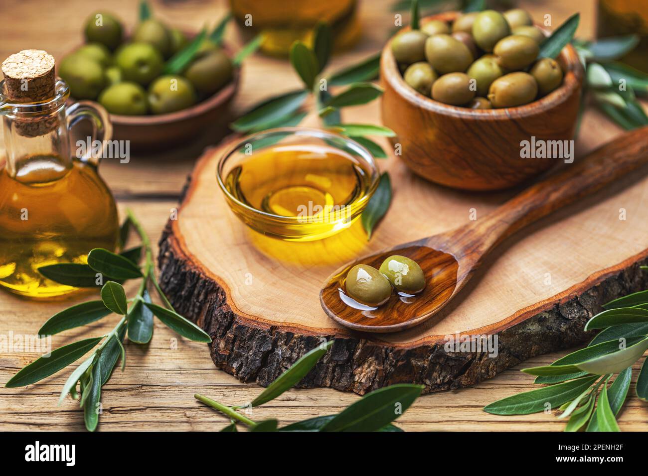 Aceite de oliva ecológico en tazón con aceitunas verdes. Concepto de comida mediterránea saludable. Foto de stock