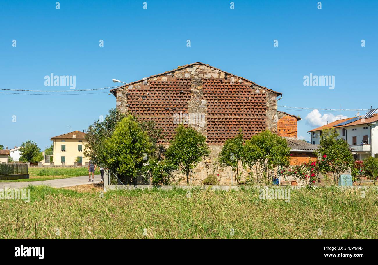 Granero de ladrillo cocido con entramado de madera en granjas en la región de la Toscana, cerca de Capannori, Lucca, Italia con ventana hecha de azulejos de espiga. PAREDES DE COTO GRATICT Foto de stock